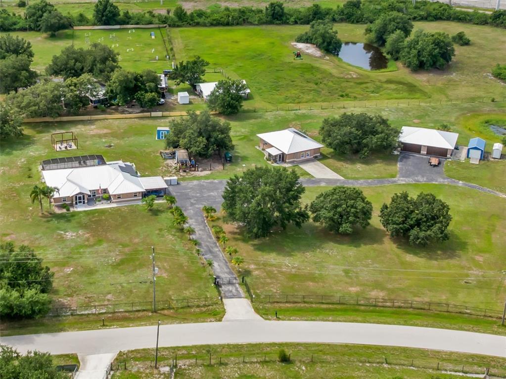 An aerial view shows a large property with multiple houses, outbuildings, and a pond — 8200 CLEVELAND DRIVE, PUNTA GORDA, FL