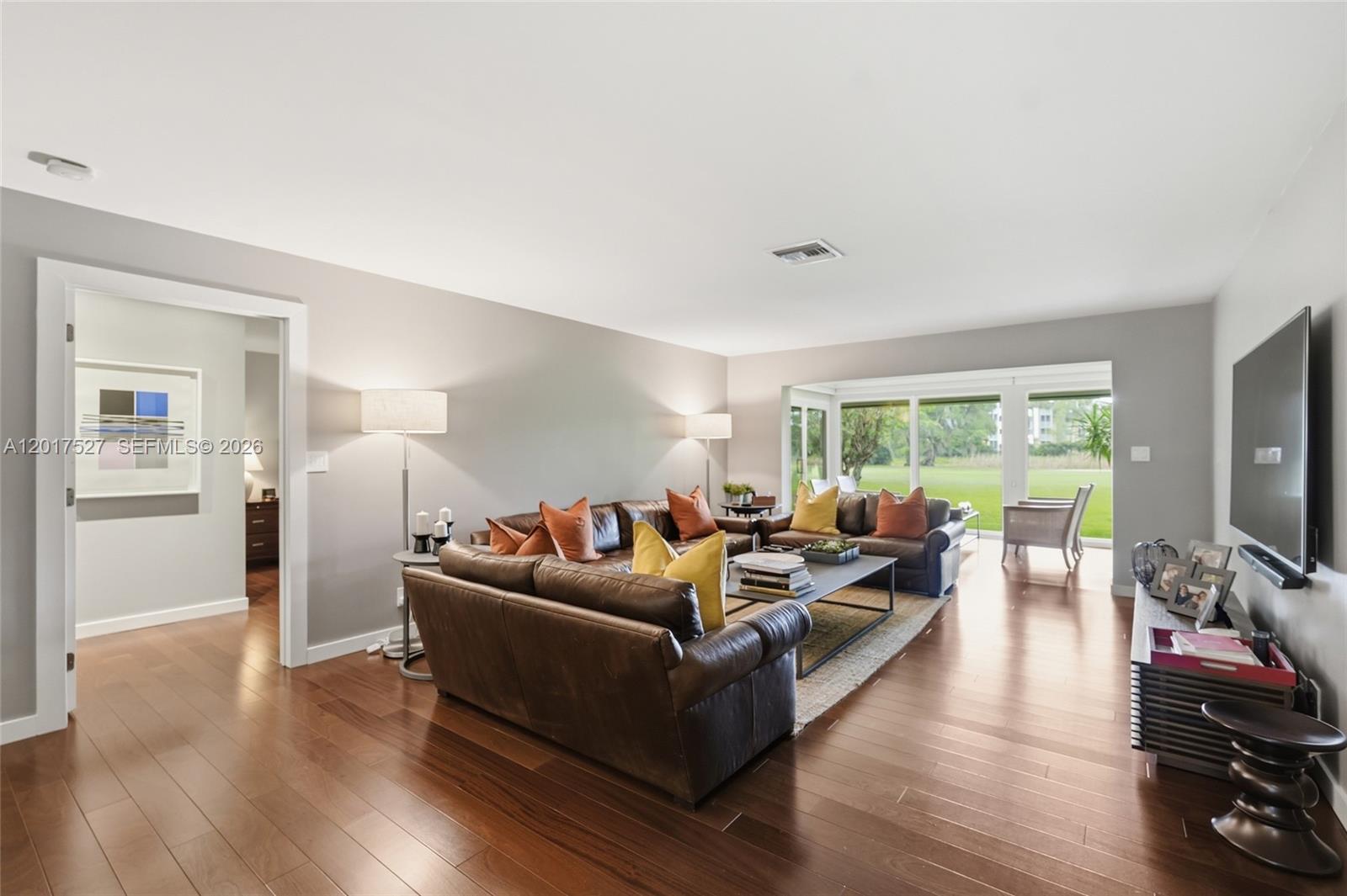 A living room features brown leather sofas, a coffee table, and sliding glass doors — 4002 S Cypress Ln # 17, Pompano Beach FL 33069, POMPANO BEACH, FL