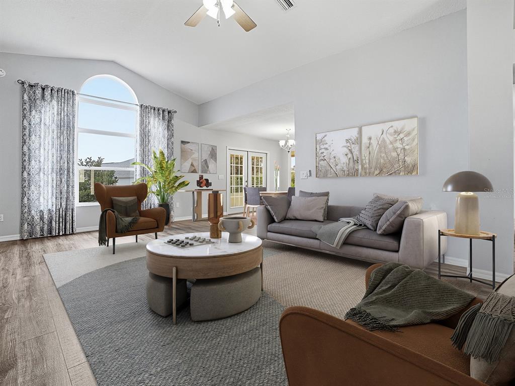 A living room with a gray sofa, two brown armchairs, and a round coffee table — 1322 GUERRA AVENUE, THE VILLAGES, FL