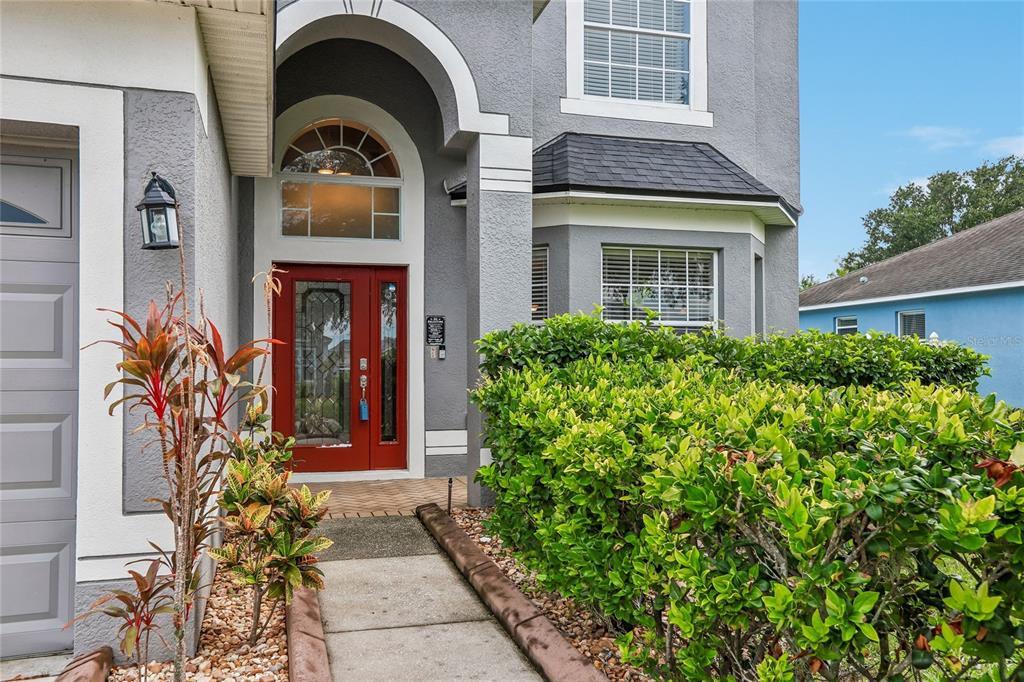 A gray two-story house features a red front door and a concrete walkway — 13231 GRAHAM YARDEN DRIVE, RIVERVIEW, FL