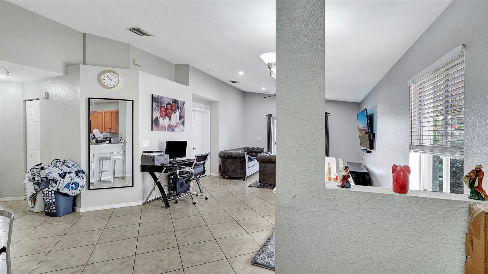 A living area with tile floors, a desk, a mirror, and a partial wall divider — 4558 SW 125th Lane, Miramar FL 33027, MIRAMAR, FL