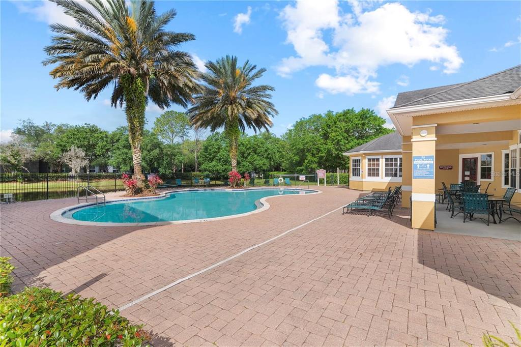 A swimming pool with a brick patio and a covered seating area under a building — 8124 CLAIRE ANN DRIVE UNIT 305, ORLANDO, FL