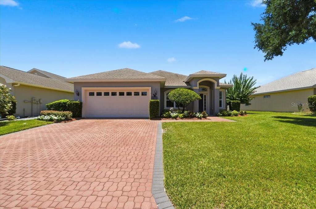 A single-story house with a paved driveway, a two-car garage, and a landscaped front yard — 3221 OAK TREE LANE, WINTER HAVEN, FL