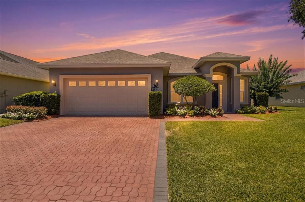 A single-story house with a paved driveway, a two-car garage, and a landscaped front yard — 3221 OAK TREE LANE, WINTER HAVEN, FL