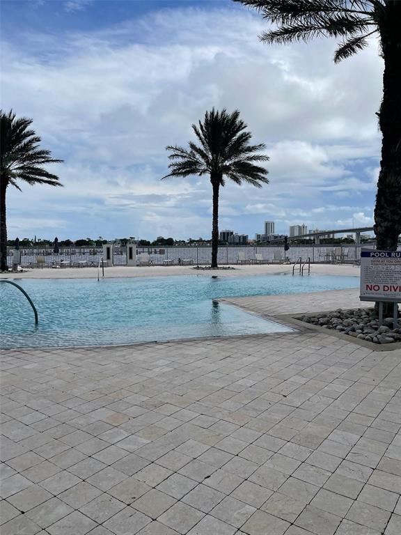 A swimming pool overlooks a bay with a distant city skyline and a bridge — 241 RIVERSIDE DRIVE UNIT 410, DAYTONA BEACH, FL