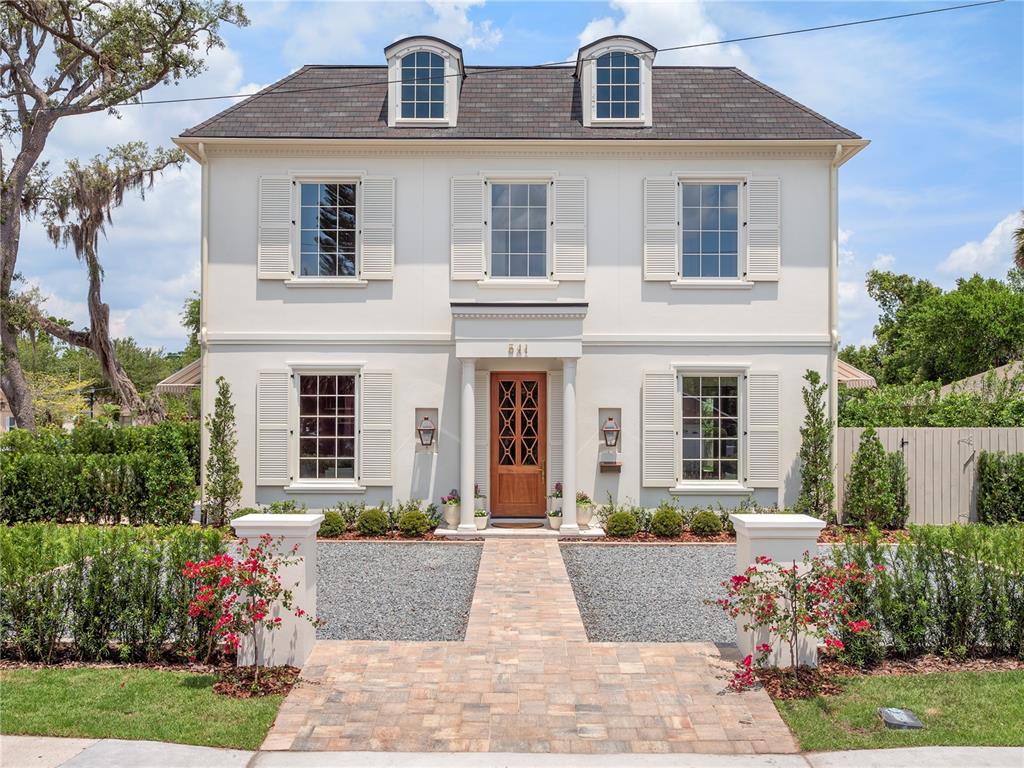 A two-story white house with a wooden front door, shutters, and a stone walkway — 541 W CANTON AVENUE, WINTER PARK, FL