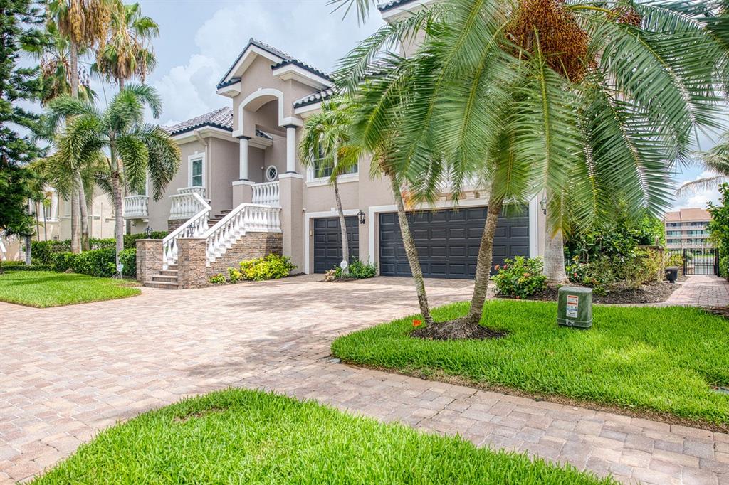 A two-story house with a beige stucco exterior, a tiled roof, and a front staircase — 6113 PASADENA POINT BOULEVARD, GULFPORT, FL
