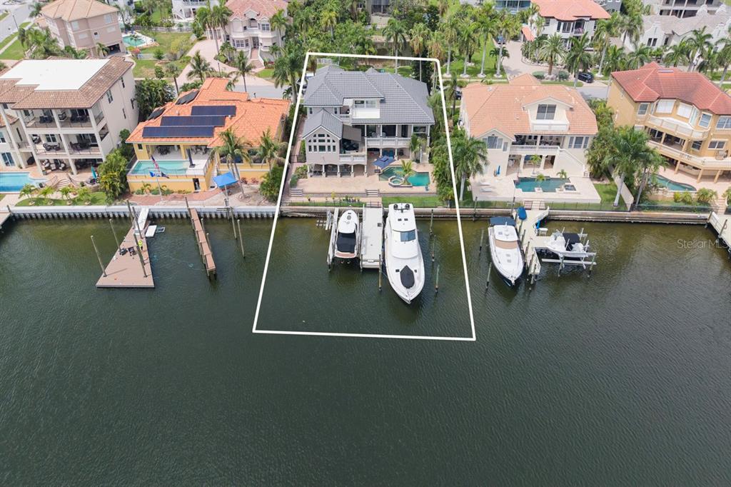 A two-story house with a stone-accented staircase, a multi-car garage, and palm trees in front — 6113 PASADENA POINT BOULEVARD, GULFPORT, FL
