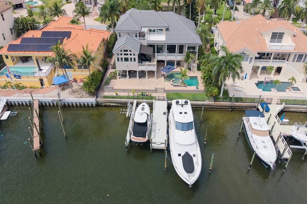 An aerial view shows a waterfront house with a private dock and two boats — 6113 PASADENA POINT BOULEVARD, GULFPORT, FL