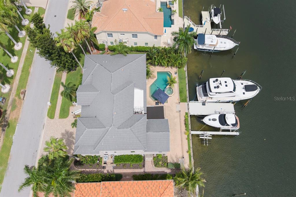 An aerial view of three waterfront houses with private docks and boats on a canal — 6113 PASADENA POINT BOULEVARD, GULFPORT, FL