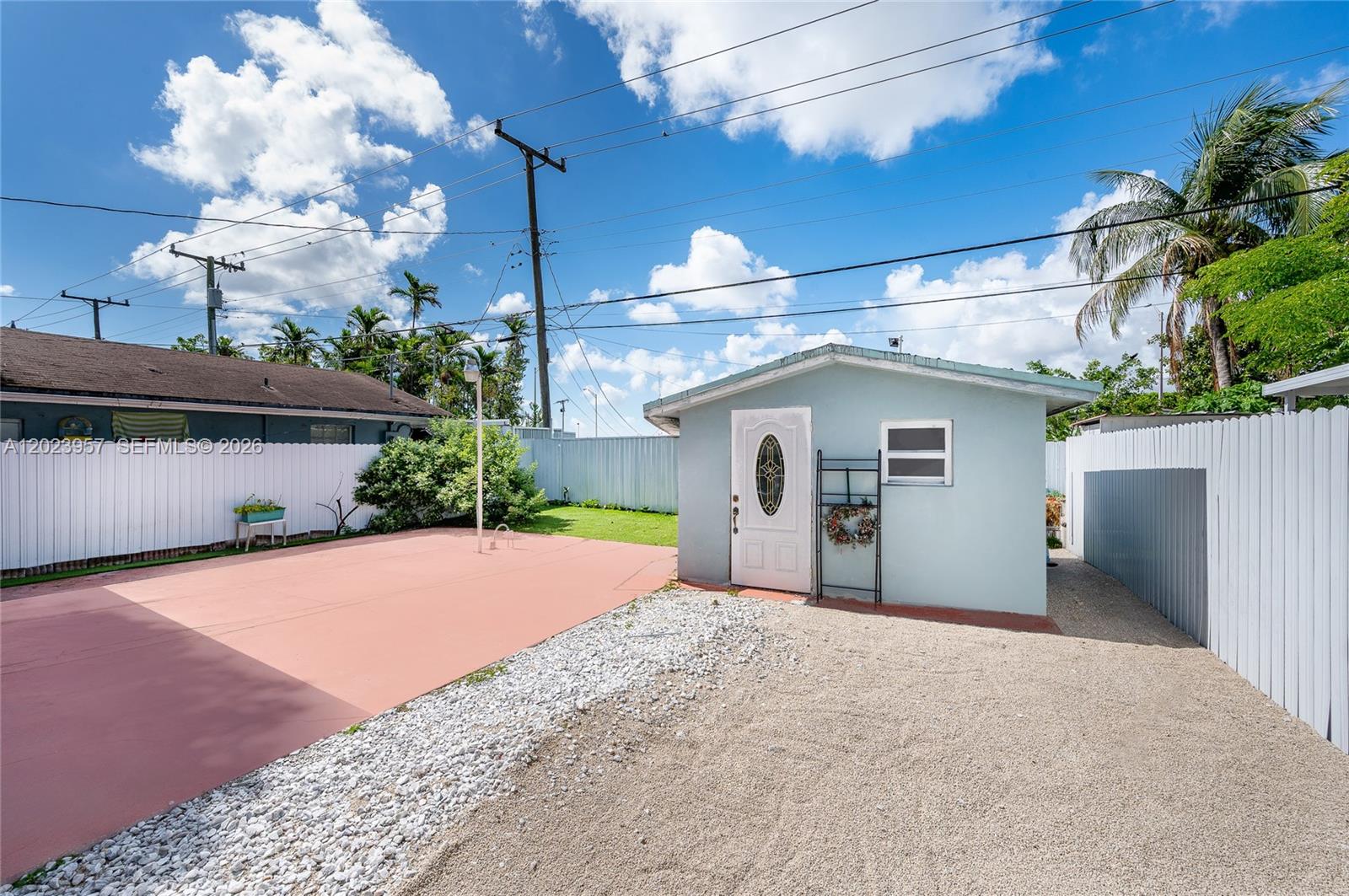 A small light blue detached building sits on a gravel and paved backyard lot — 228 W 18th St, Hialeah FL 33010, HIALEAH, FL