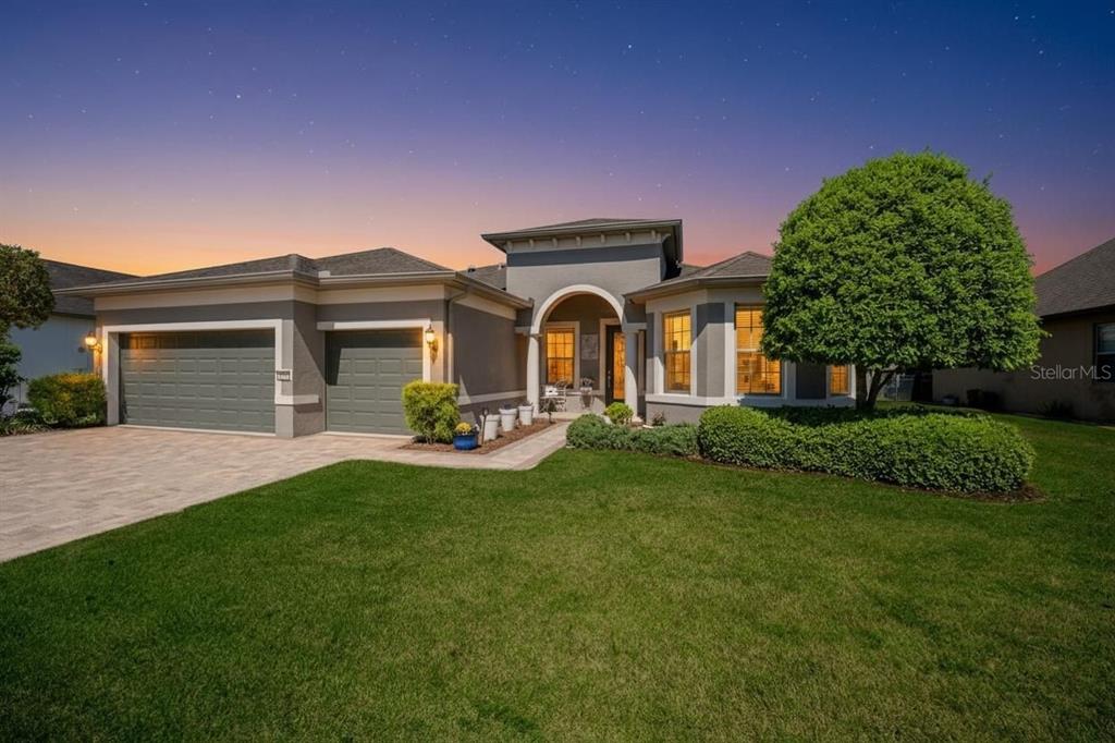 A single-story house with a two-car garage, arched entryway, and a manicured front lawn — 9186 SW 70TH LOOP, OCALA, FL