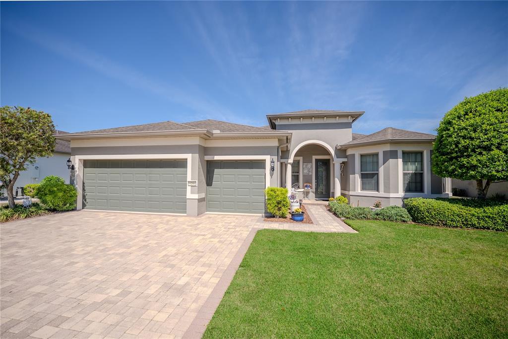A single-story house with a paved driveway, two garage doors, and a covered front entrance — 9186 SW 70TH LOOP, OCALA, FL