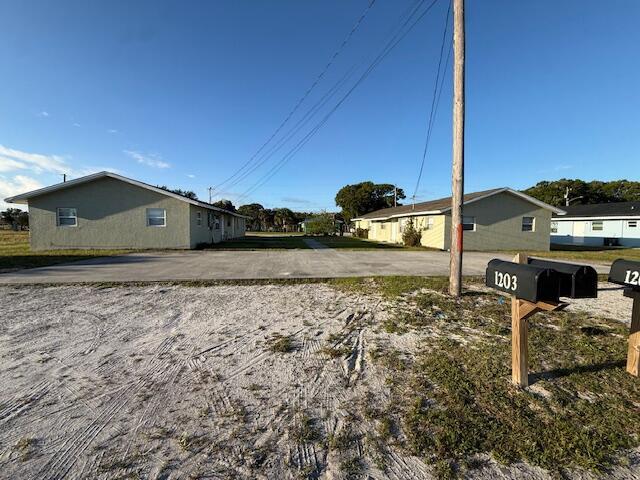 Two single-story apartment buildings face a shared concrete parking lot with mailboxes in the foreground — 1205 Ave K # B, Fort Pierce FL 34950, FORT PIERCE, FL