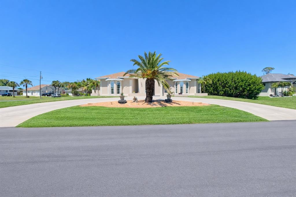 A single-story house with a circular driveway and a large palm tree in the center — 2 LONG MEADOW ROAD, ROTONDA WEST, FL