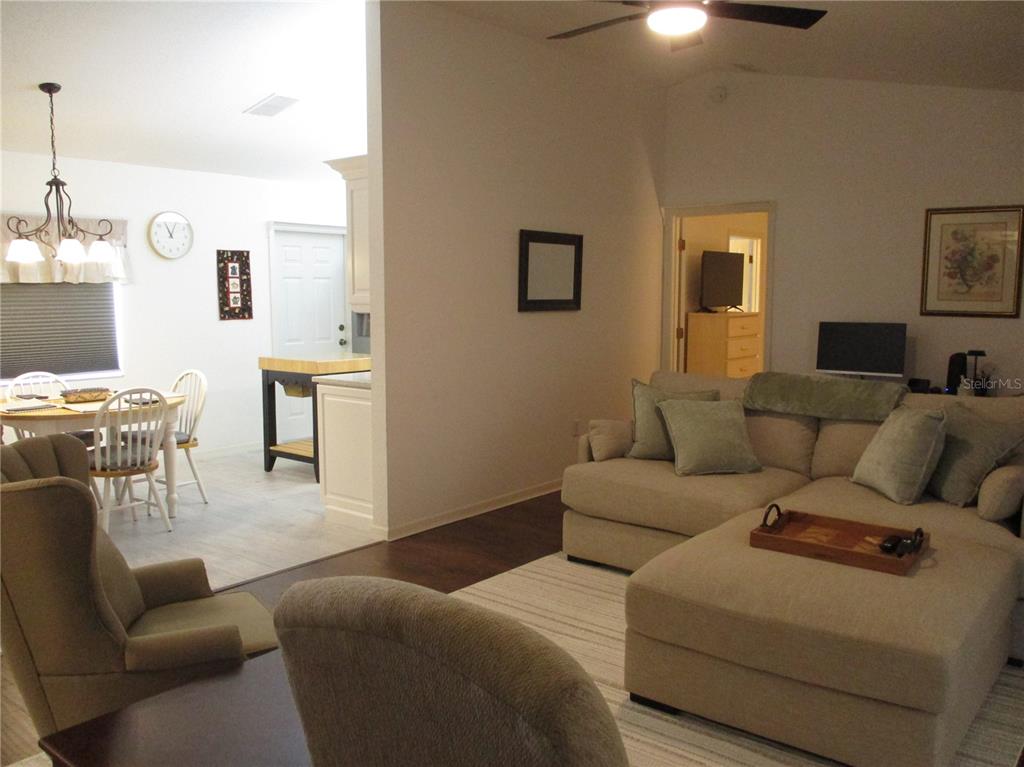 A living room with a sectional sofa flows into a dining area with a table — 11653 SW 138TH LANE, DUNNELLON, FL