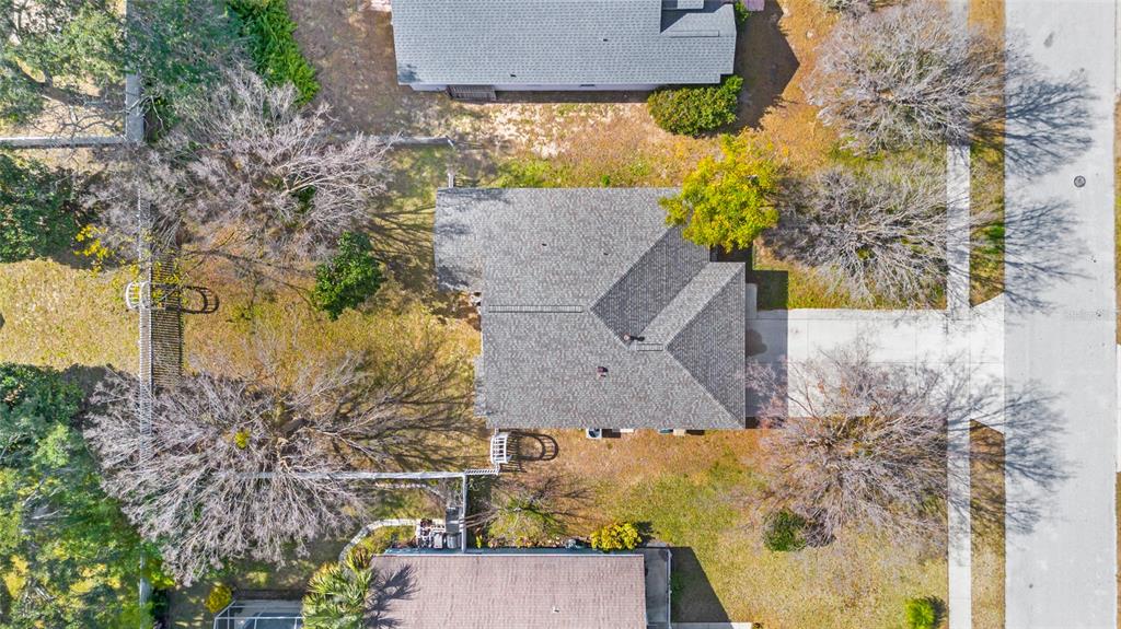 An aerial view shows a single-story house with a gray roof surrounded by trees — 10314 PATRICK DRIVE, LEESBURG, FL