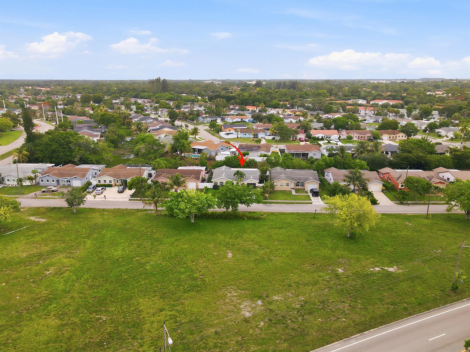 An aerial view shows a residential street with a single-story house marked by a red arrow — 22267 SW 57th Avenue, Boca Raton FL 33428, BOCA RATON, FL