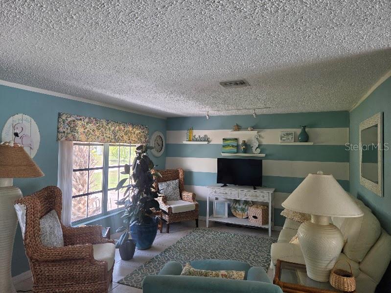 A covered patio features a swimming pool, outdoor furniture, and a tiled floor — 18190 STEELE AVENUE, PORT CHARLOTTE, FL