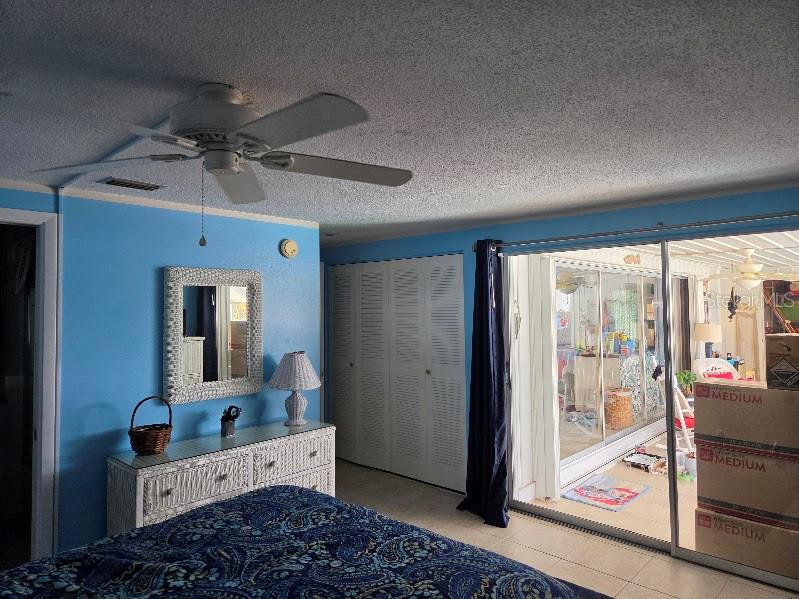 A screened-in swimming pool patio features a dining set, lounge chairs, and a blue rug — 18190 STEELE AVENUE, PORT CHARLOTTE, FL