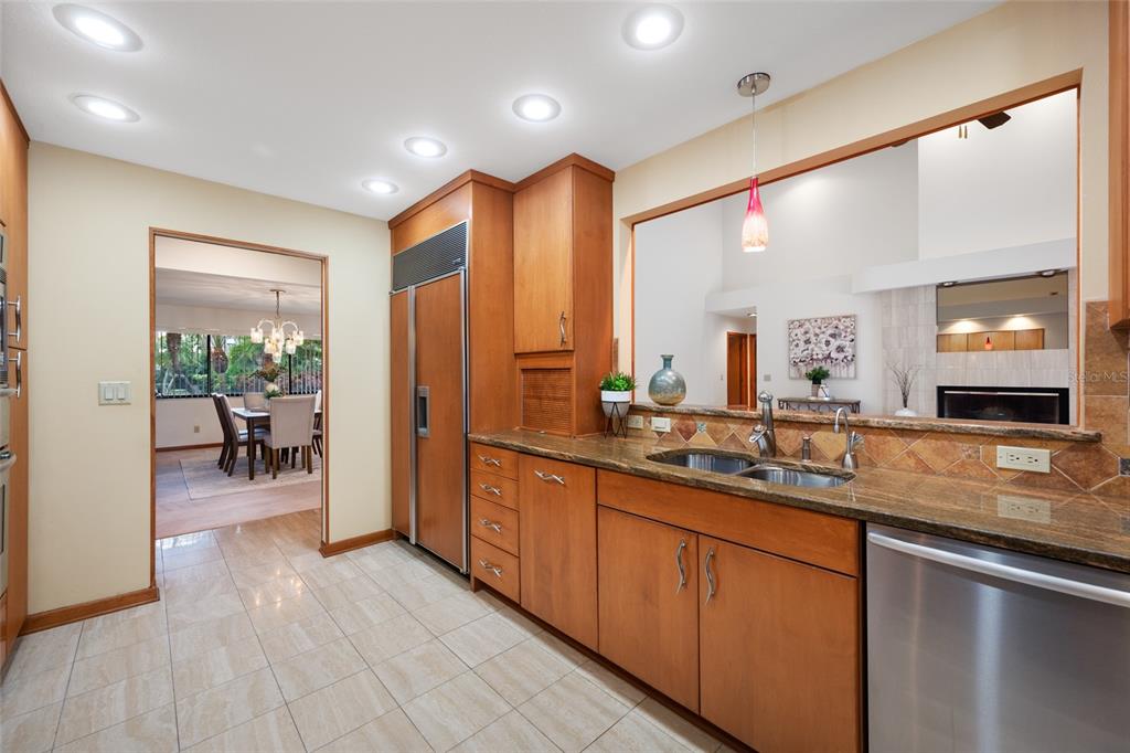 A spacious living room features a large red sectional sofa, a fireplace, and vaulted ceilings — 9807 COMPASS POINT WAY, TAMPA, FL