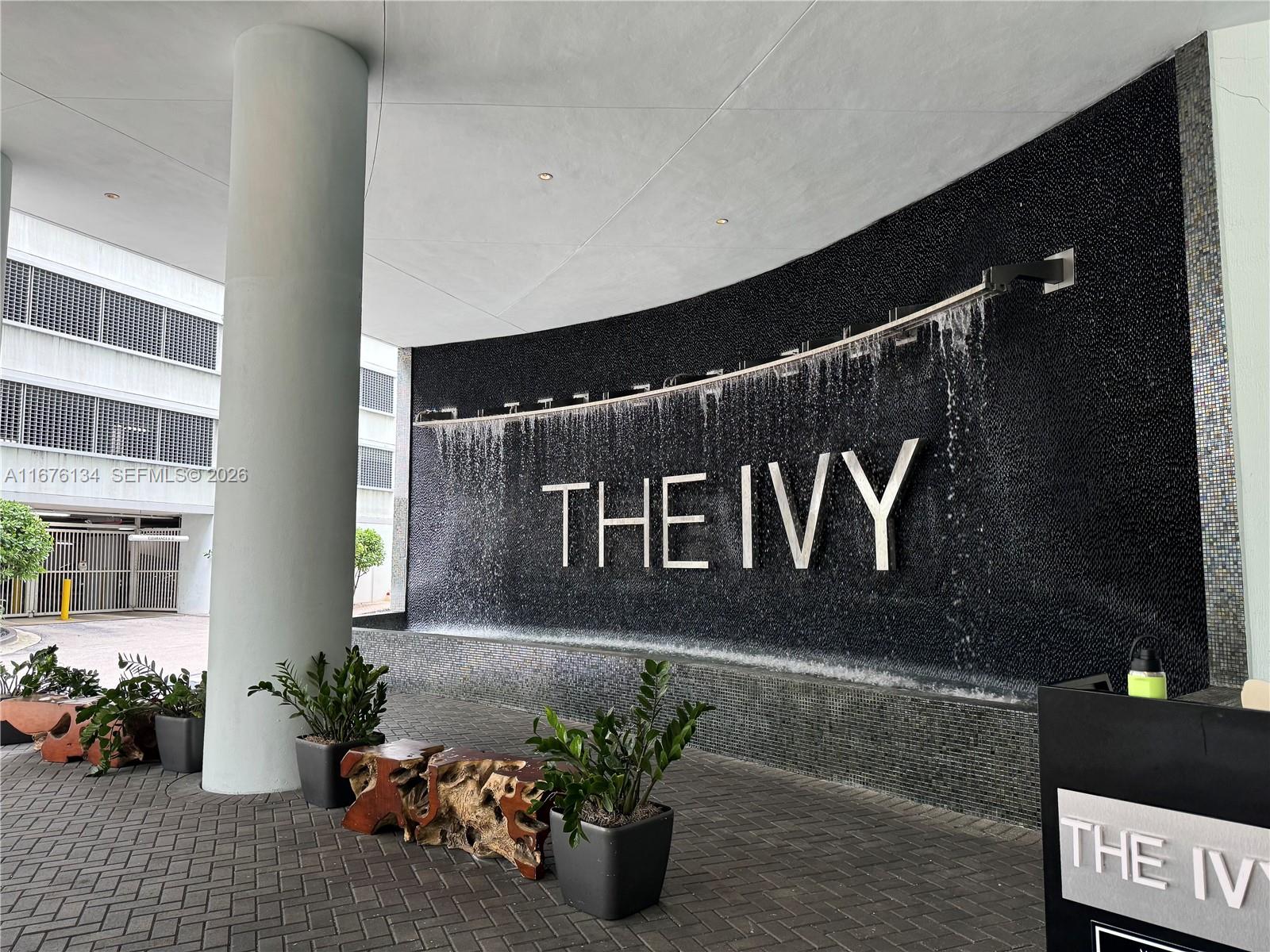 A curved water feature with the text THE IVY sits in front of a building entrance — 90 SW 3 ST # 3210, Miami FL 33130, MIAMI, FL