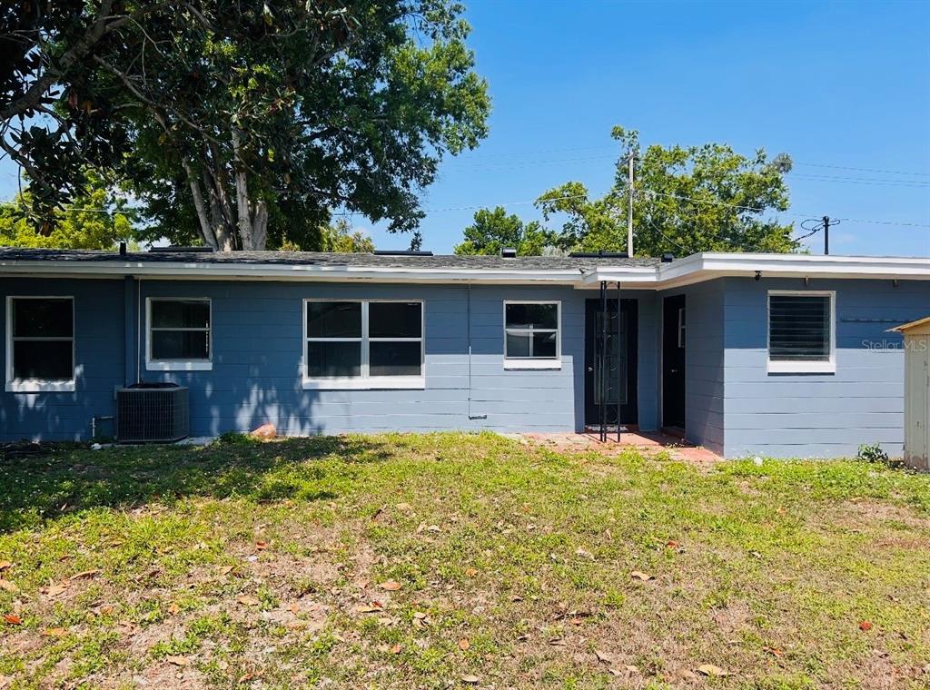 The exterior of a blue single-story house with a flat roof and a grassy yard — 2214 Ave B SW SW 2214 AVE B SW, WINTER HAVEN, FL