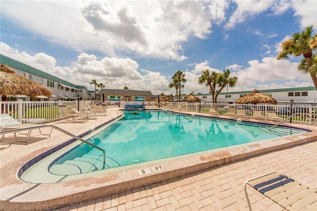 A view of an exterior apartment walkway featuring unit number 15, windows, and a door — 5356 81ST STREET N UNIT 15, ST PETERSBURG, FL