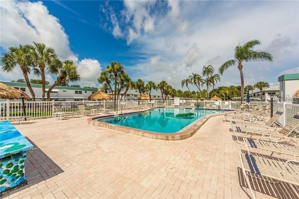 A kitchen features light wood cabinets, a double-basin sink, a microwave, and a gas stove — 5356 81ST STREET N UNIT 15, ST PETERSBURG, FL