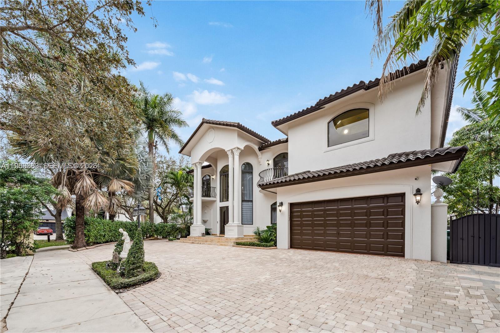 A two-story white stucco house features a brown garage door and a paved driveway — 8200 NW 163rd St, Miami Lakes FL 33016, MIAMI LAKES, FL