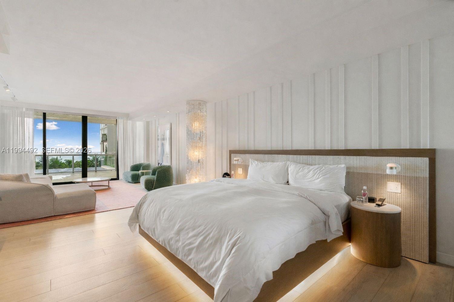 A modern bedroom features a platform bed, vertical wall paneling, and a balcony with ocean views — 2201 Collins Ave # 532, Miami Beach FL 33139, MIAMI BEACH, FL