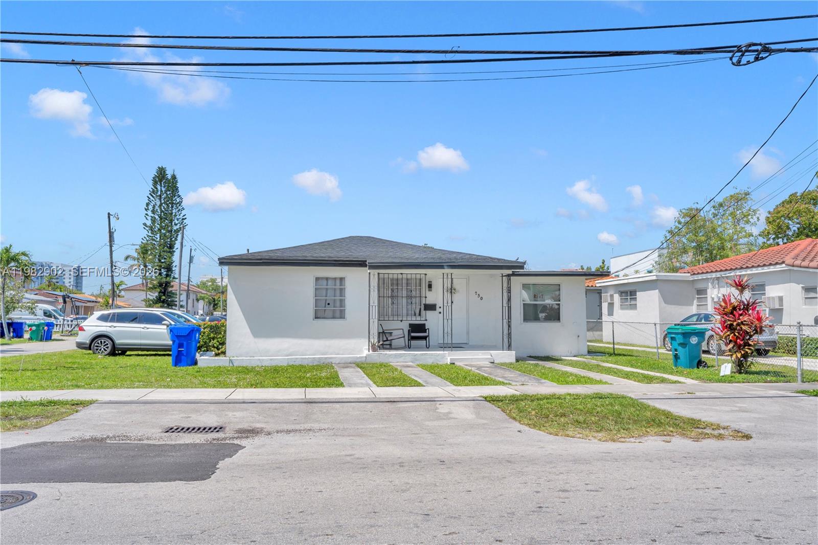 A single-story white house with a dark roof and a front porch sits on a lawn — 250 NW 34th Ave, Miami FL 33125, MIAMI, FL