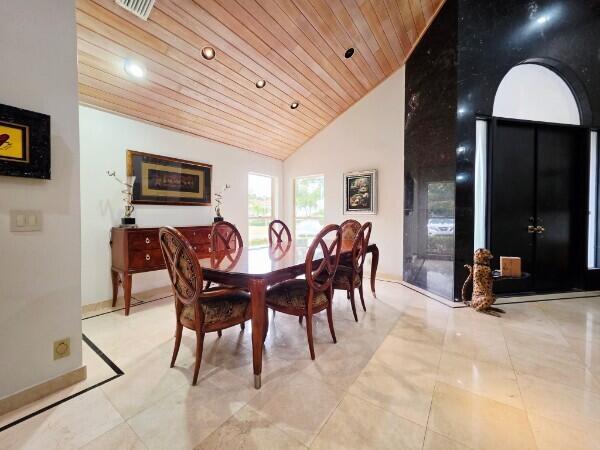 A dining room features a wooden vaulted ceiling, marble floors, and a dark wood table — 56 Northwoods Lane, Boynton Beach FL 33436, BOYNTON BEACH, FL