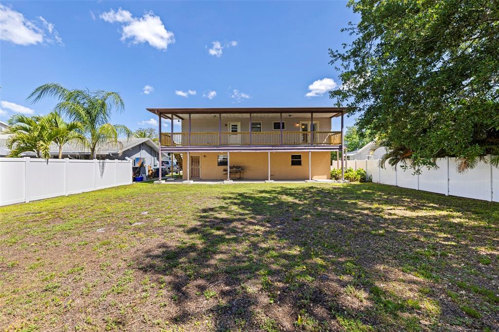 The exterior of a two-story house features a large upper deck and a covered patio — 334 CROSSWINDS DRIVE, PALM HARBOR, FL