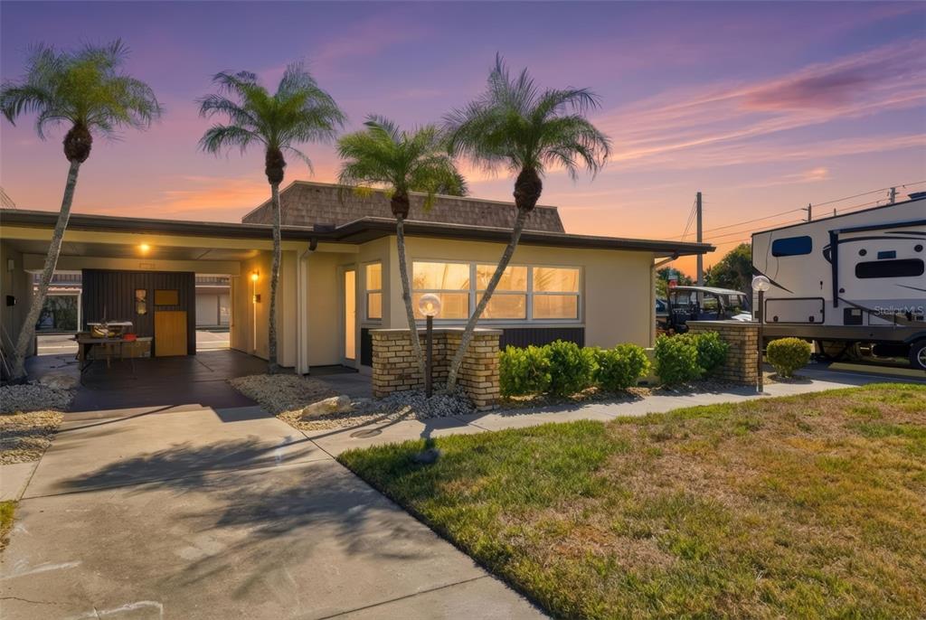 A single-story house with a carport, palm trees, and a large RV parked alongside — 5153 TURQUOISE LANE UNIT 102, NEW PORT RICHEY, FL