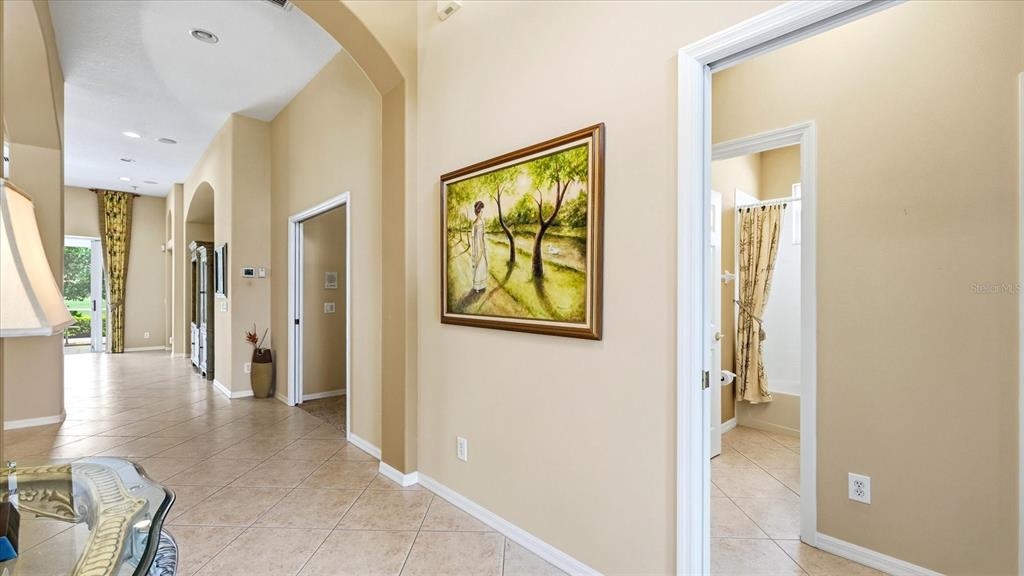 A hallway with tile floors, an arched ceiling, and a painting on the wall — 5704 WHITE JASMINE WAY, NORTH PORT, FL