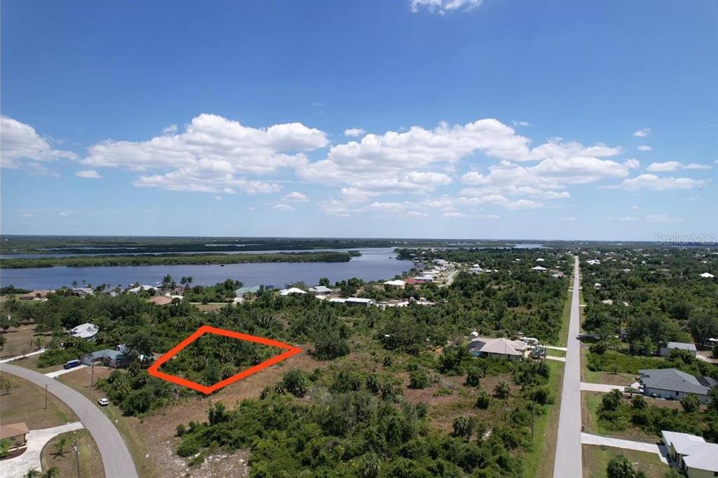 An aerial view shows a vacant, rectangular lot outlined in red near a body of water — 2080 WAVERLY TER STREET, PORT CHARLOTTE, FL