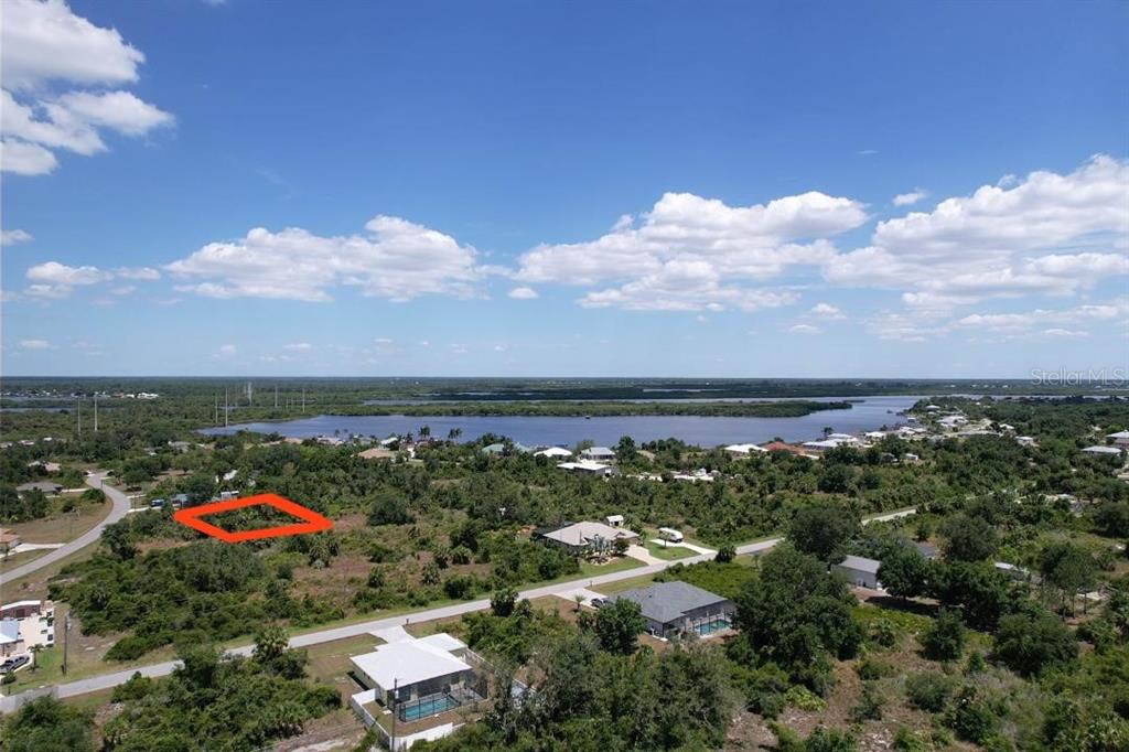An aerial view shows a vacant lot outlined in red amidst a residential landscape — 2080 WAVERLY TER STREET, PORT CHARLOTTE, FL