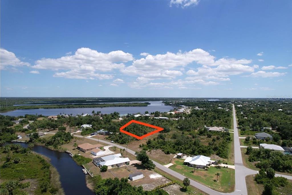 An aerial view shows a vacant, rectangular lot outlined in red near a waterway — 2080 WAVERLY TER STREET, PORT CHARLOTTE, FL