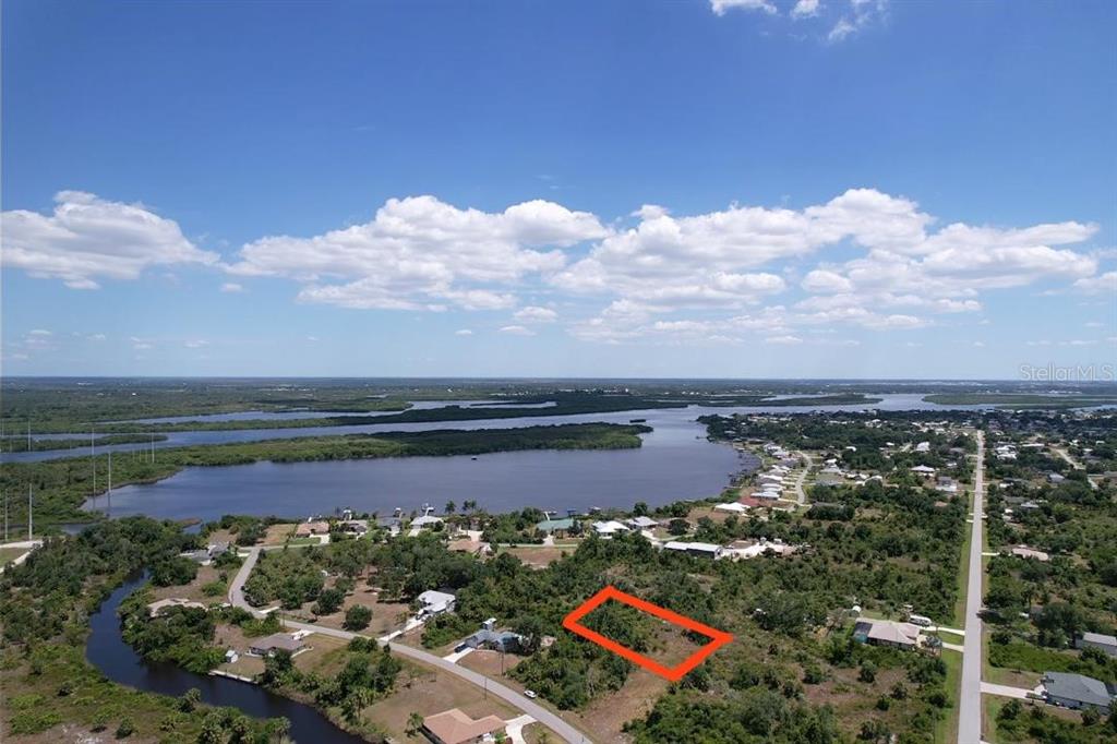 An aerial view shows a vacant lot outlined in orange near a body of water — 2080 WAVERLY TER STREET, PORT CHARLOTTE, FL
