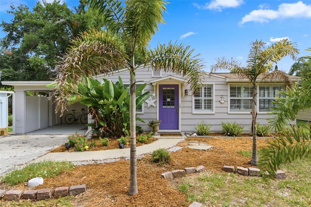 A single-story house with light gray siding, a purple front door, and two palm trees — 652 LEXINGTON STREET, DUNEDIN, FL