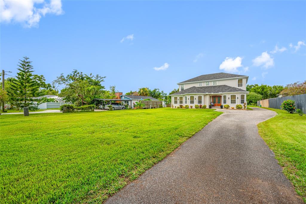A two-story house with a large front lawn and a paved driveway — 13030 DELWOOD ROAD, TAMPA, FL