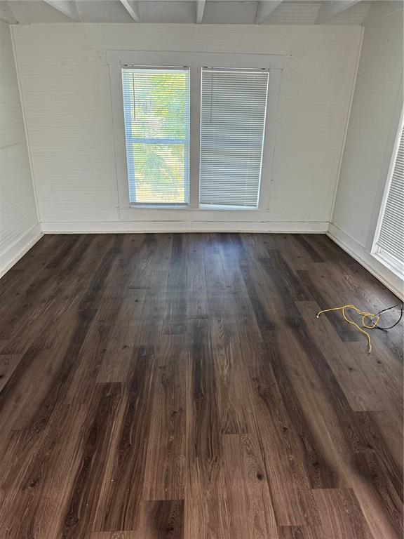 An empty room features white walls, a window with blinds, and dark wood-look flooring — 7306 EARLWOOD AVENUE UNIT 2, MOUNT DORA, FL
