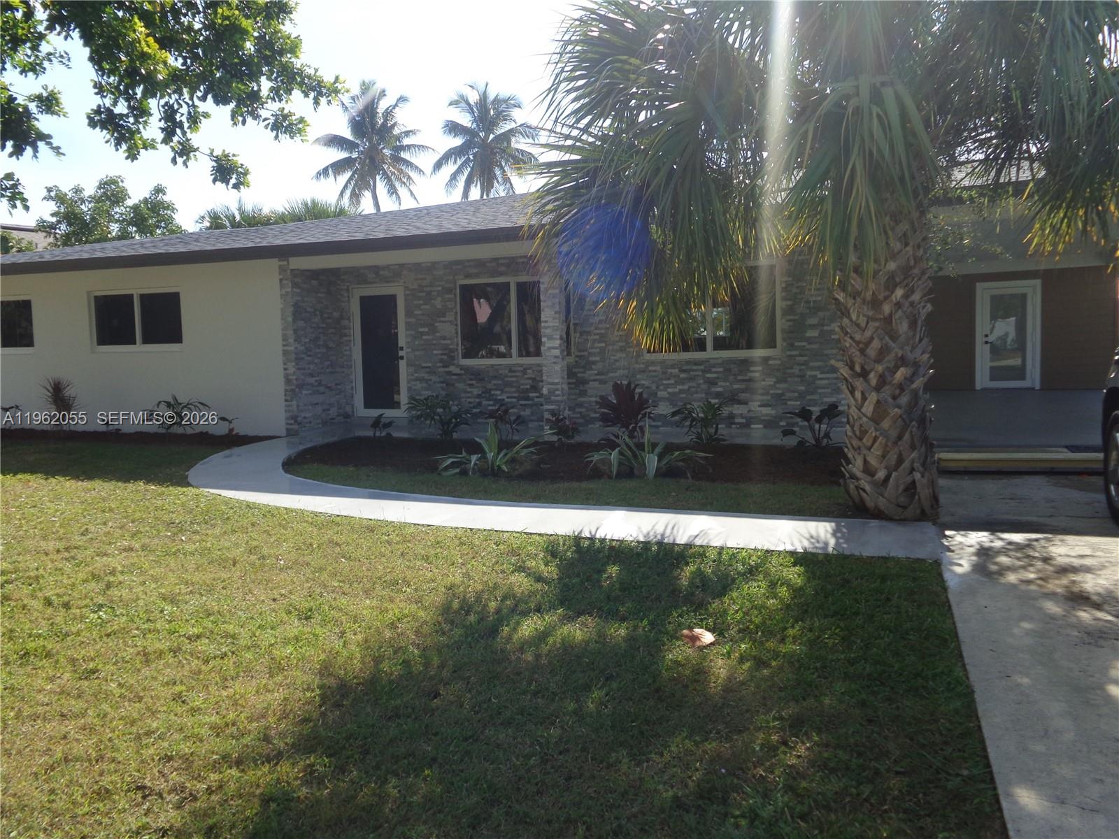 A single-story house features a stone facade, a curved concrete walkway, and a palm tree — 1565 Thumb Point Dr, Fort Pierce FL 34949, FORT PIERCE, FL