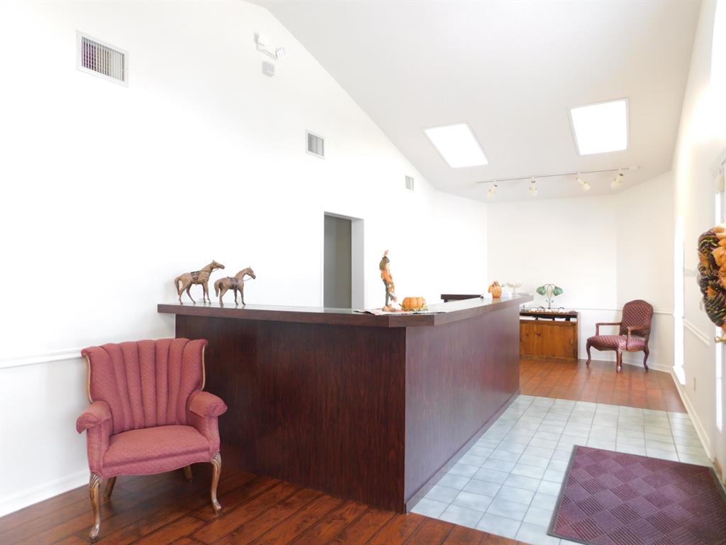 A reception area features a dark wood counter, vaulted ceilings with skylights, and two armchairs — 4635 & 4611 N CARL G. ROSE HIGHWAY, HERNANDO, FL