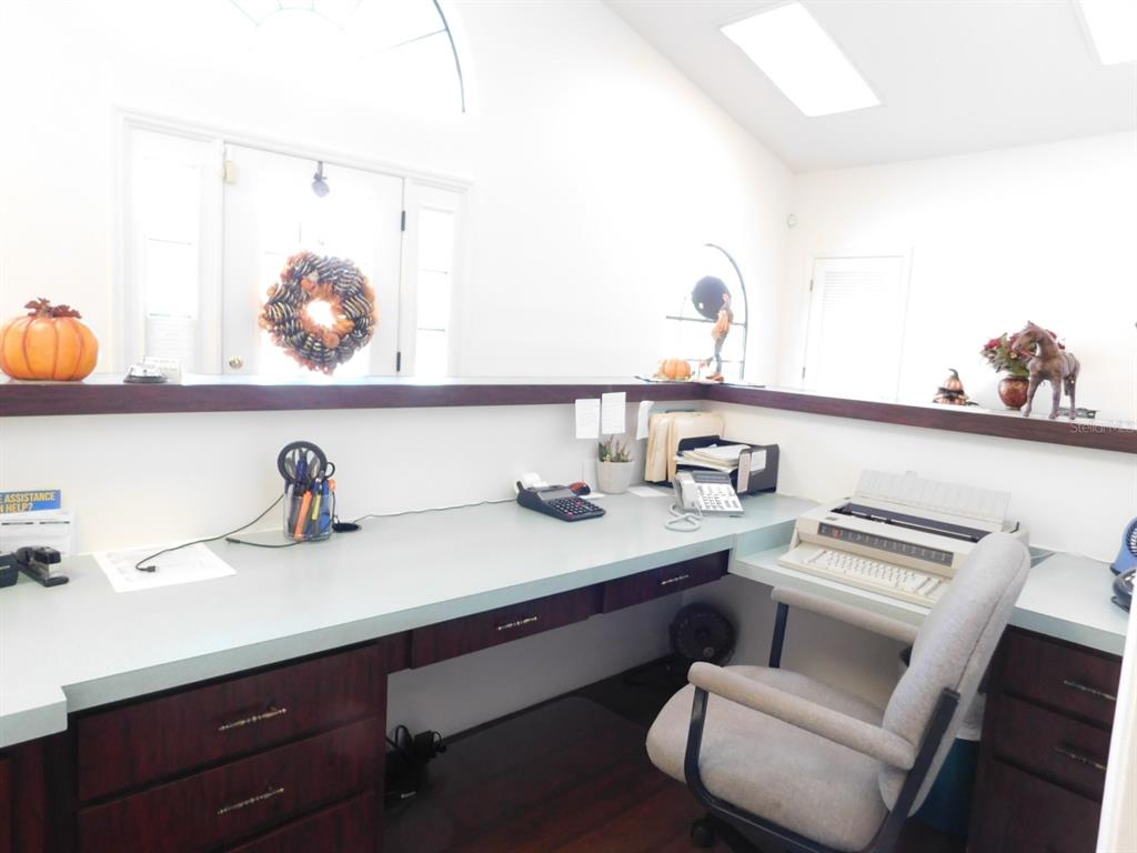 An office space features a long desk with dark wood cabinets and a typewriter — 4635 & 4611 N CARL G. ROSE HIGHWAY, HERNANDO, FL