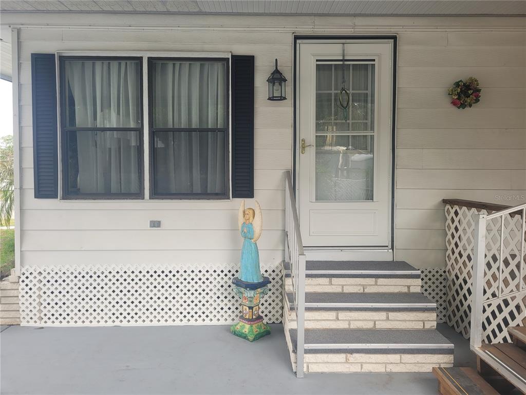 An exterior view shows a white house with a front door, steps, and a window — 3027 GALAXY LANE, LAKELAND, FL