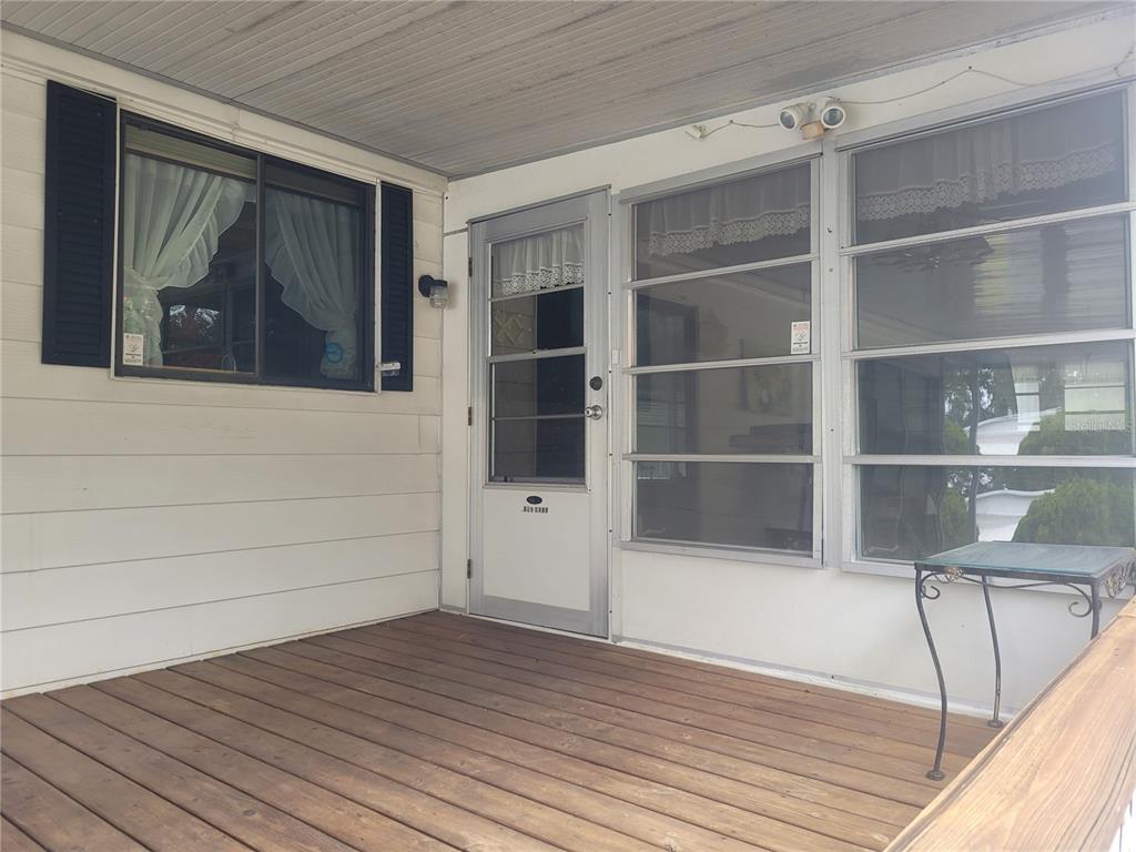 A wooden deck leads to a white door and windows on the side of a house — 3027 GALAXY LANE, LAKELAND, FL