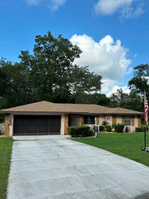 A single-story house with a brown shingled roof, a garage, and a concrete driveway — 10335 N ABBY DRIVE, CITRUS SPRINGS, FL