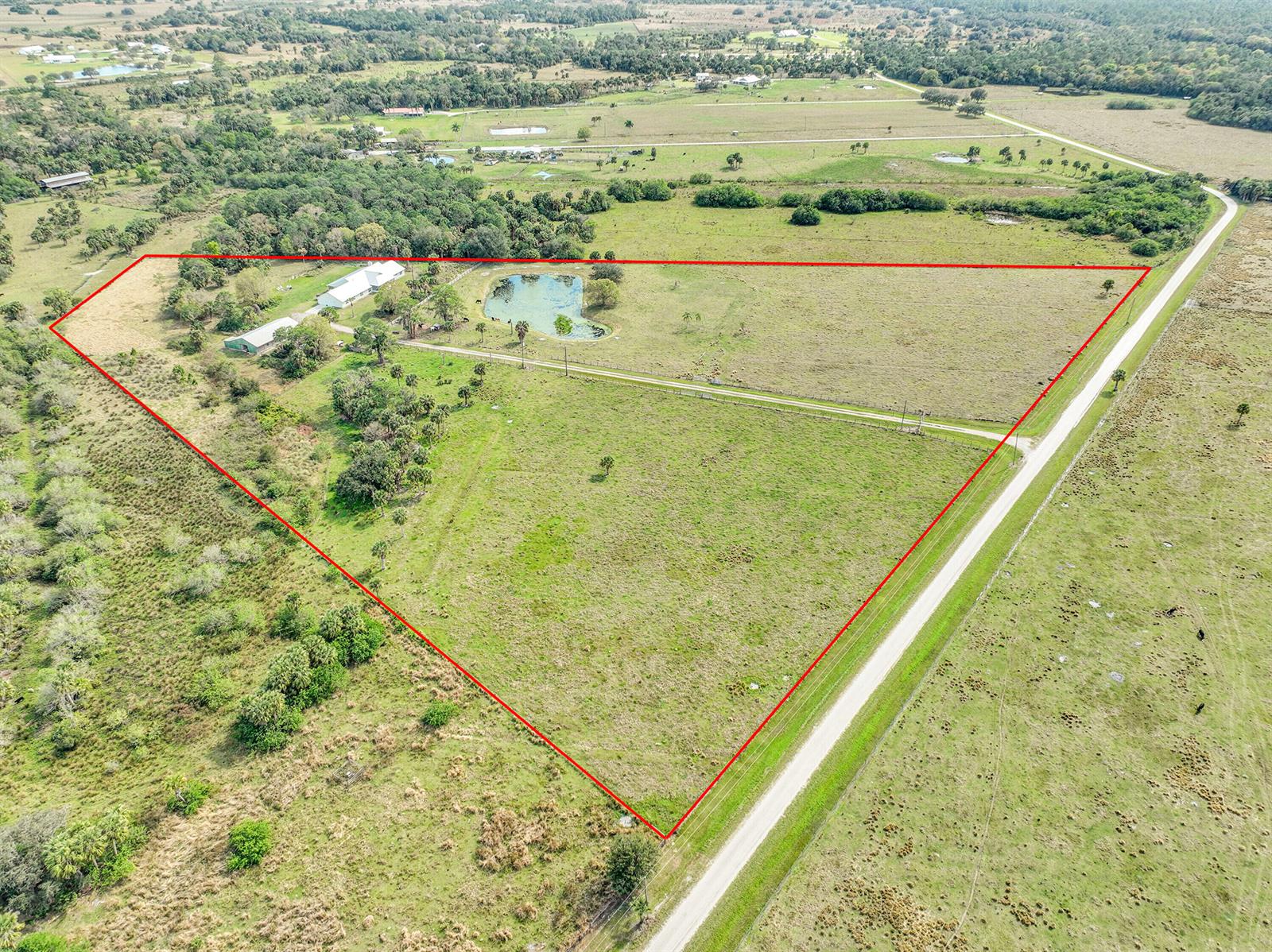 An aerial view shows a rural property with a house, pond, and pasture outlined in red — 3901 Wild Turkey Trail Trail, Okeechobee FL 34974, OKEECHOBEE, FL